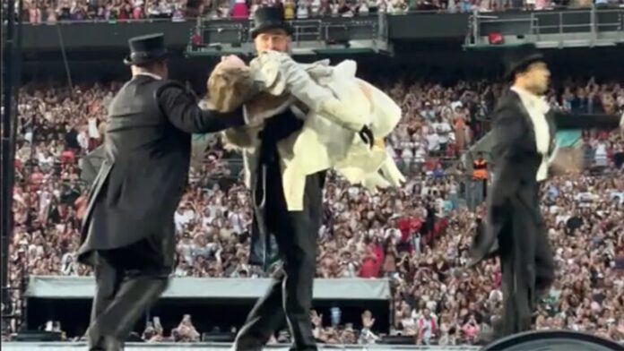 When Taylor Swift initially introduces her boyfriend Travis Kelce to the public while he's wearing a tuxedo and carrying her at their Wembley concert, the crowd goes CRAZY.
